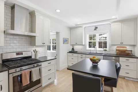 a kitchen with stainless steel appliances a sink stove and cabinets