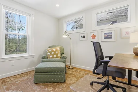 a view of a workspace with furniture and a window