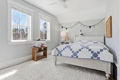 a bedroom with a bed and a painting on the wall