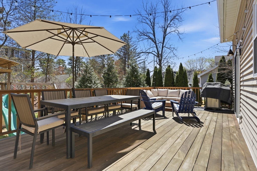 69 Potter Street Concord, MA 01742 - Photo 26 of 31 a view of a roof deck with table and chairs under an umbrella