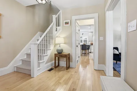 a view of entryway and hall with wooden floor