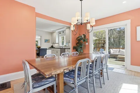 a dining room with furniture a chandelier and wooden floor