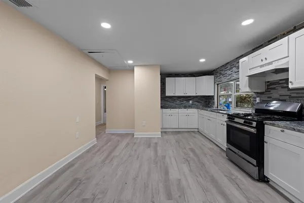 a large kitchen with stainless steel appliances granite countertop a stove a sink and a refrigerator