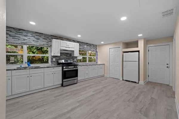 a kitchen with a refrigerator and a stove top oven