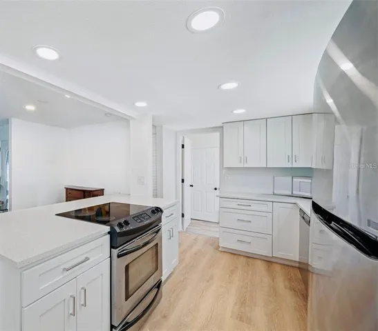a kitchen that has a stove and white cabinets