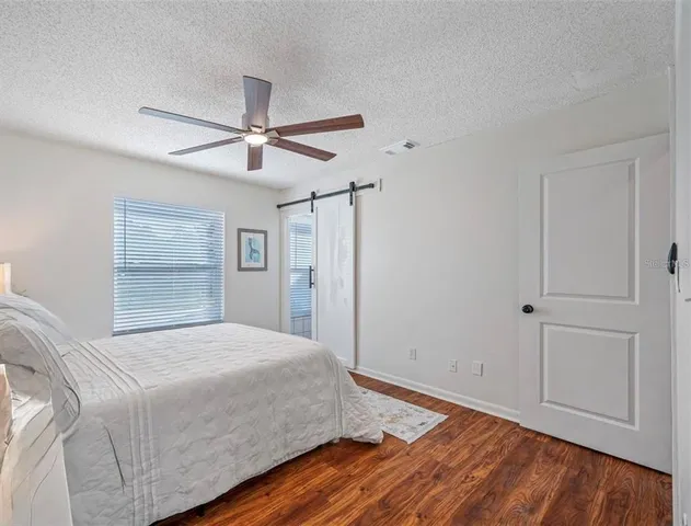 a bedroom with a bed and a ceiling fan