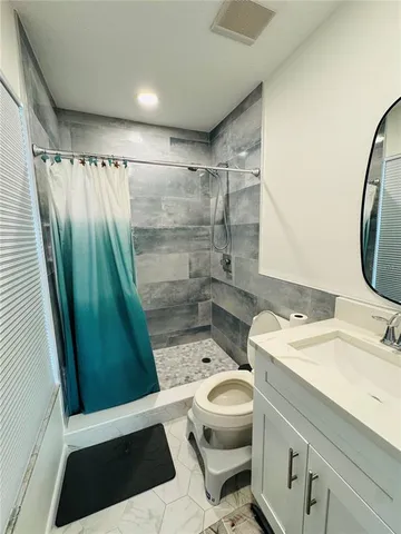a bathroom with a sink a toilet and a shower