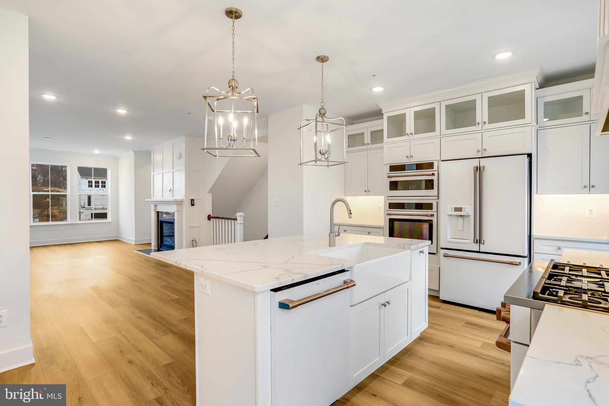 1885 Shookstown Road Frederick, MD 21702 - Photo 16 of 47 a large white kitchen with granite countertop a stove a sink dishwasher a refrigerator and white cabinets with wooden floor