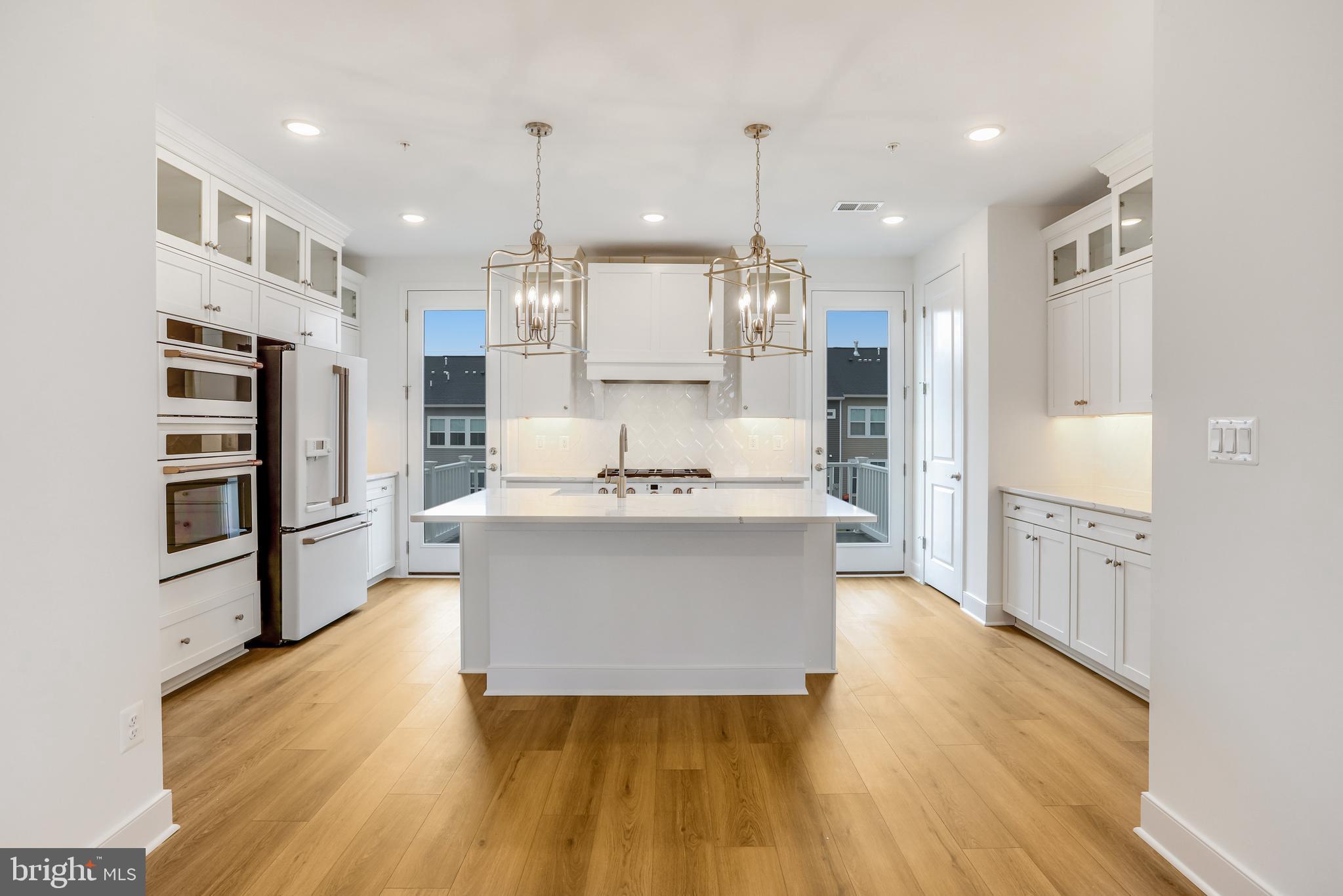 1885 Shookstown Road Frederick, MD 21702 - Photo 10 of 47 a large kitchen with stainless steel appliances kitchen island a large counter top and a wooden floors