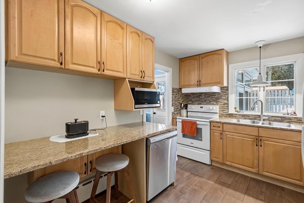79 High Street Uxbridge, MA 01569 - Photo 4 of 35 a kitchen with stainless steel appliances granite countertop a sink dishwasher stove top oven and cabinets with wooden floor