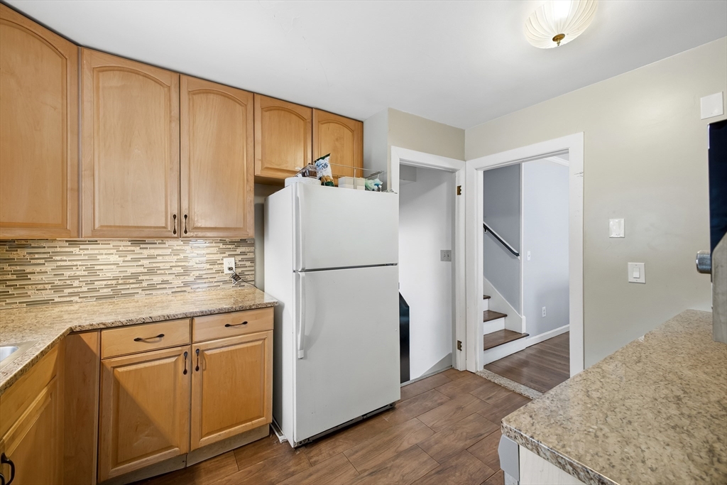 79 High Street Uxbridge, MA 01569 - Photo 5 of 35 a kitchen with granite countertop a refrigerator a sink and white cabinets
