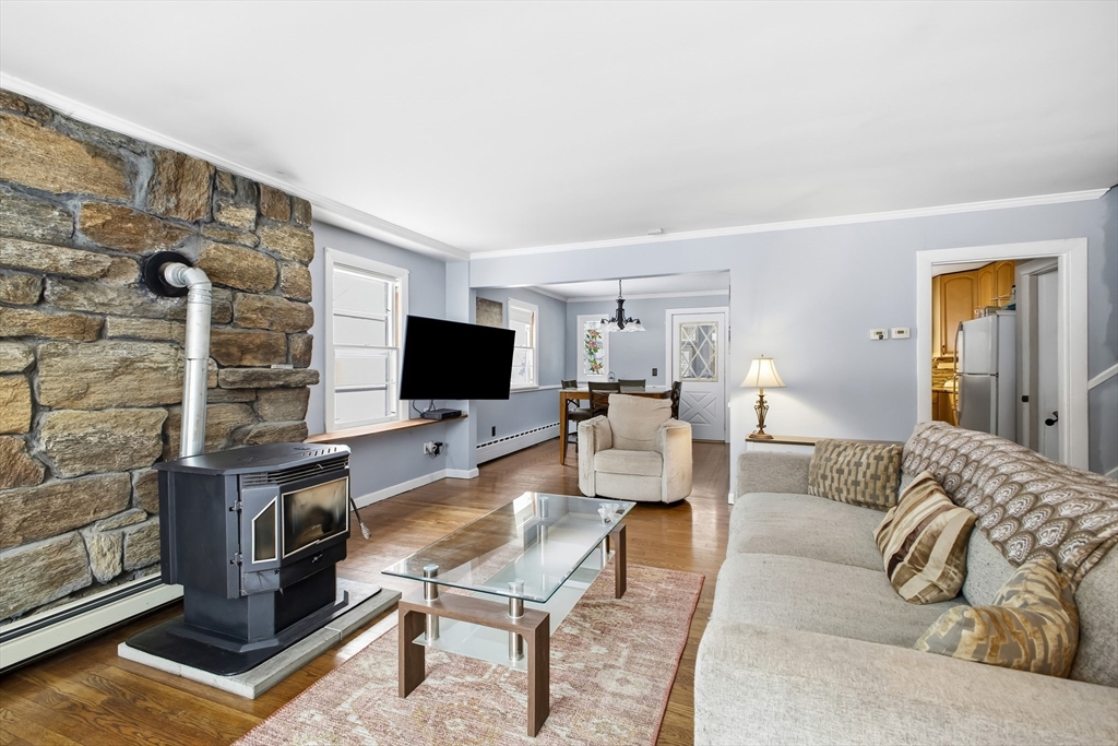 79 High Street Uxbridge, MA 01569 - Photo 8 of 35 a living room with furniture a flat screen tv and a fireplace