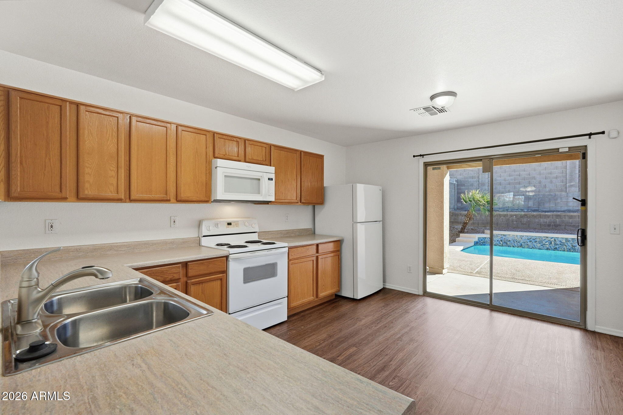 211 East Valley View Drive Phoenix, AZ 85042 - Photo 11 of 47 a kitchen that has a sink and a stove with wooden floor
