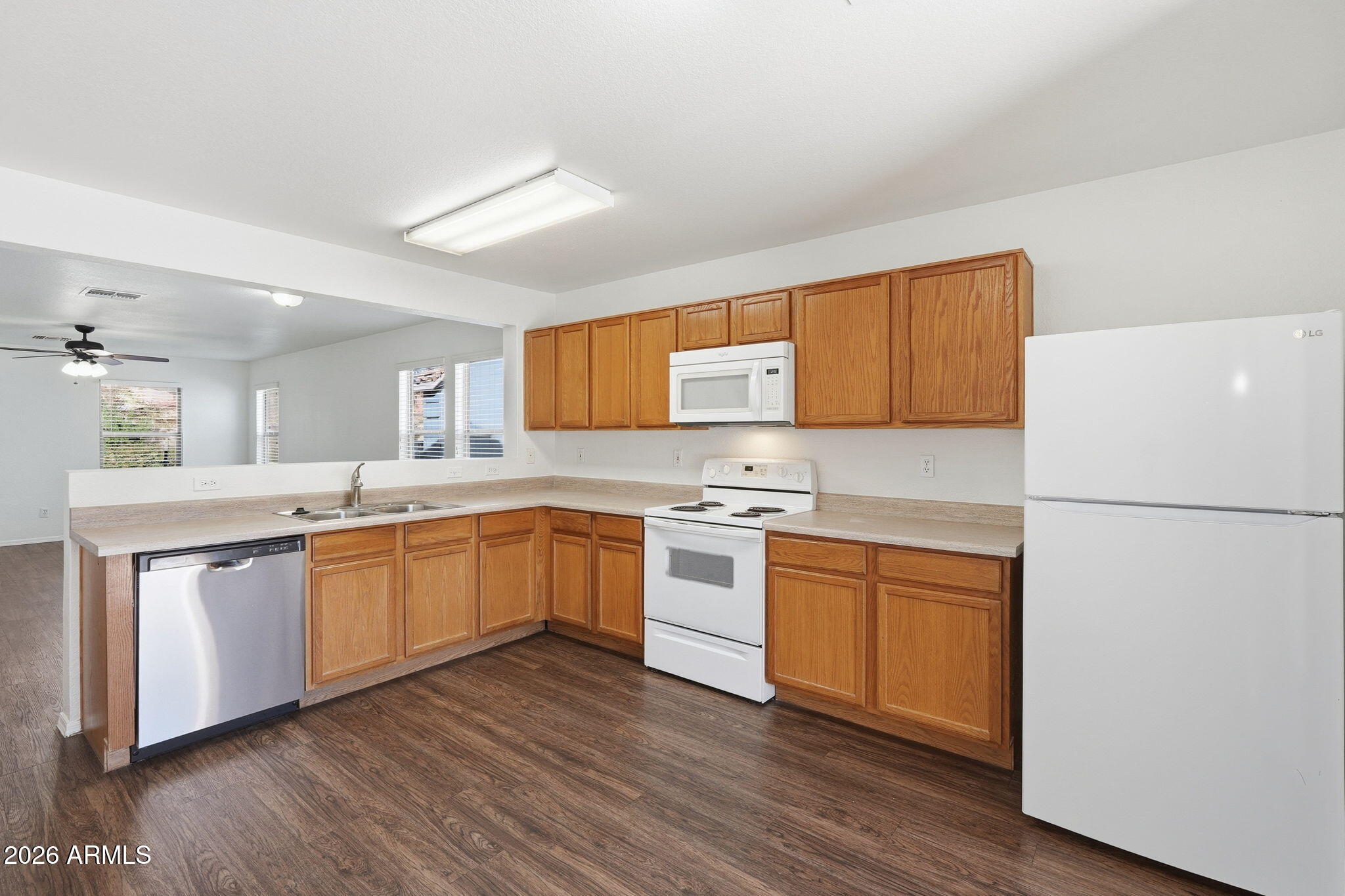 211 East Valley View Drive Phoenix, AZ 85042 - Photo 12 of 47 a kitchen with stainless steel appliances white cabinets and wooden floor