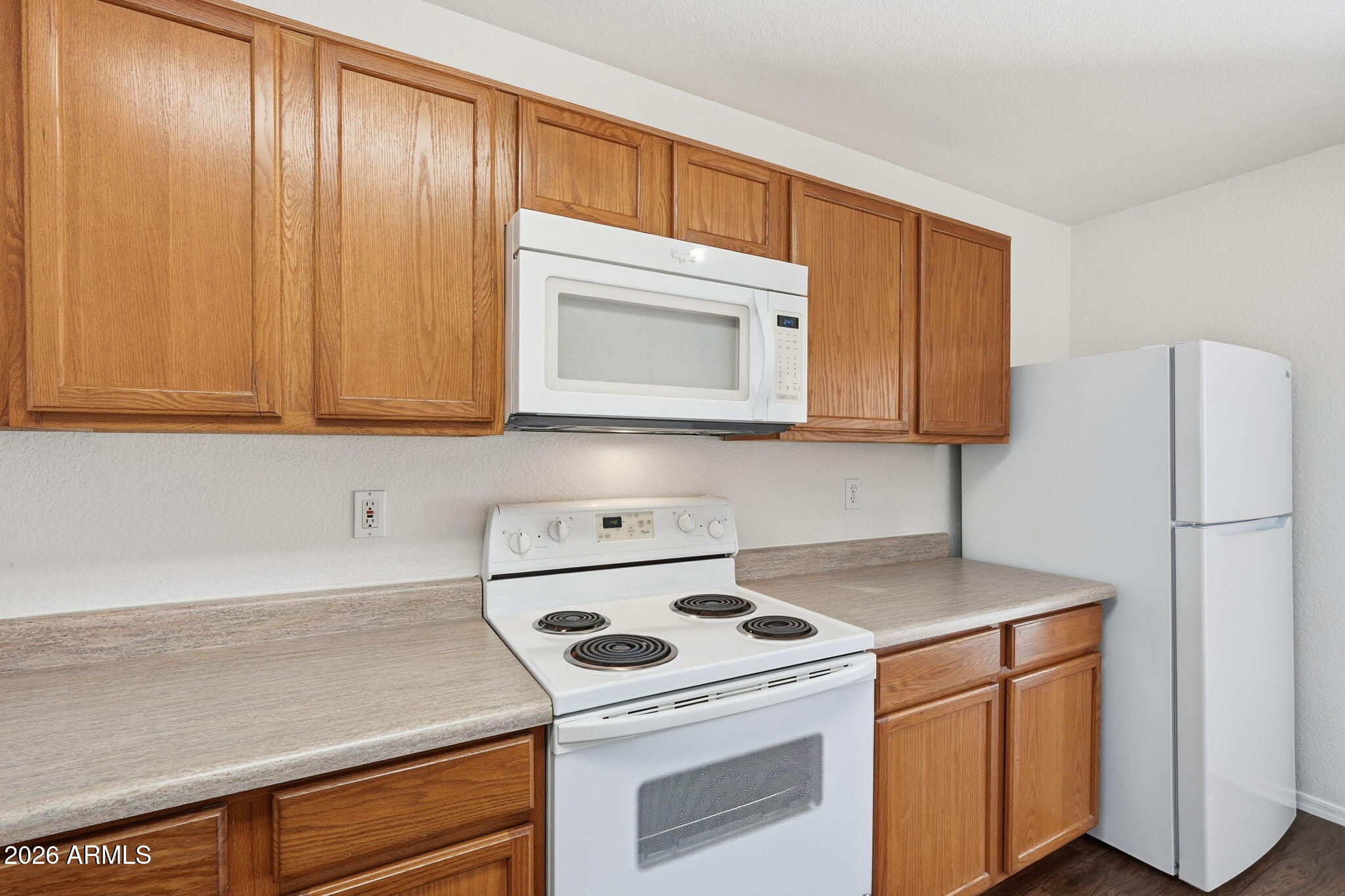 211 East Valley View Drive Phoenix, AZ 85042 - Photo 15 of 47 a kitchen with stainless steel appliances granite countertop wooden cabinets a stove a sink and a white refrigerator with wooden floor