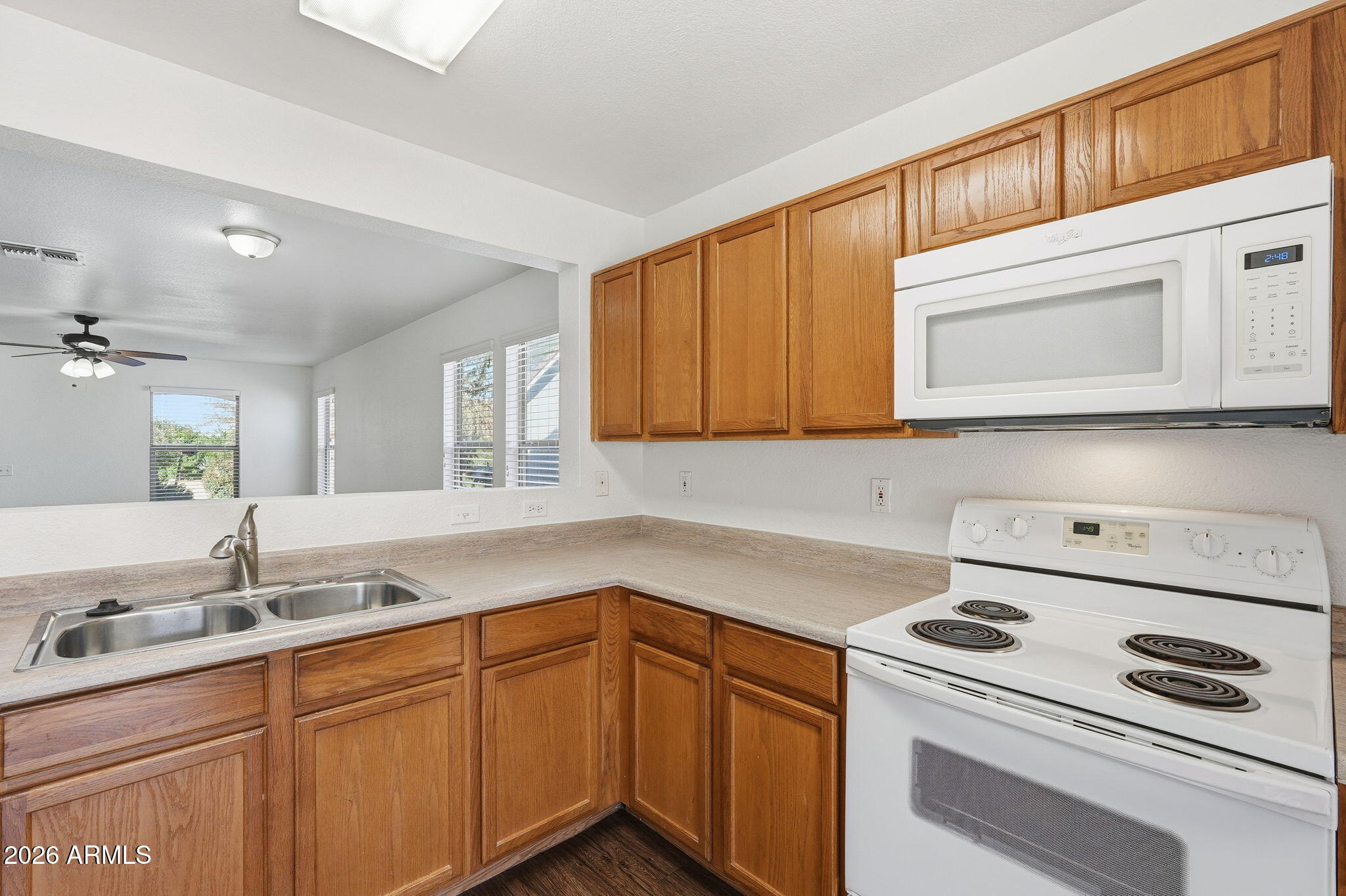 211 East Valley View Drive Phoenix, AZ 85042 - Photo 16 of 47 a kitchen with stainless steel appliances granite countertop a sink and cabinets with wooden floor