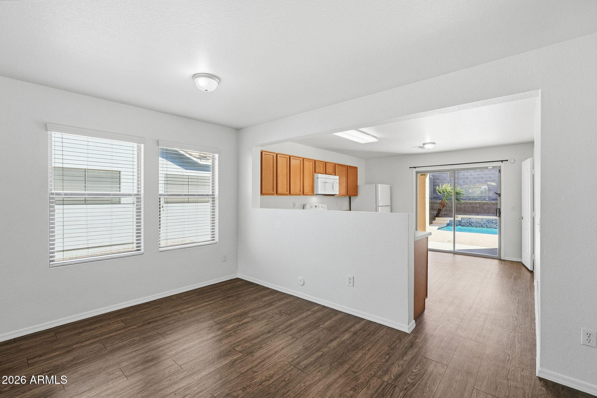 211 East Valley View Drive Phoenix, AZ 85042 - Photo 18 of 47 an empty room with wooden floor and windows