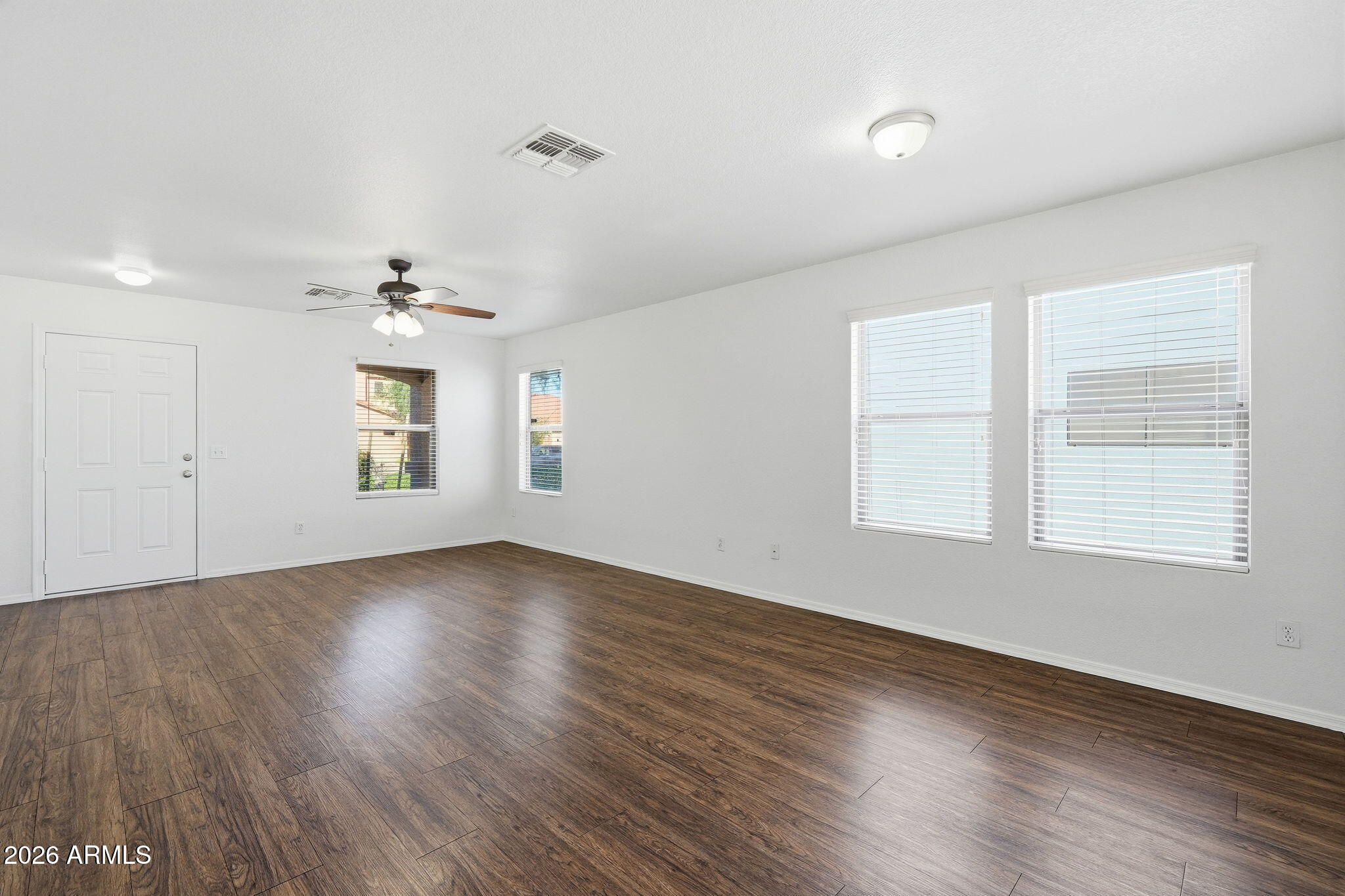 211 East Valley View Drive Phoenix, AZ 85042 - Photo 20 of 47 an empty room with wooden floor and windows
