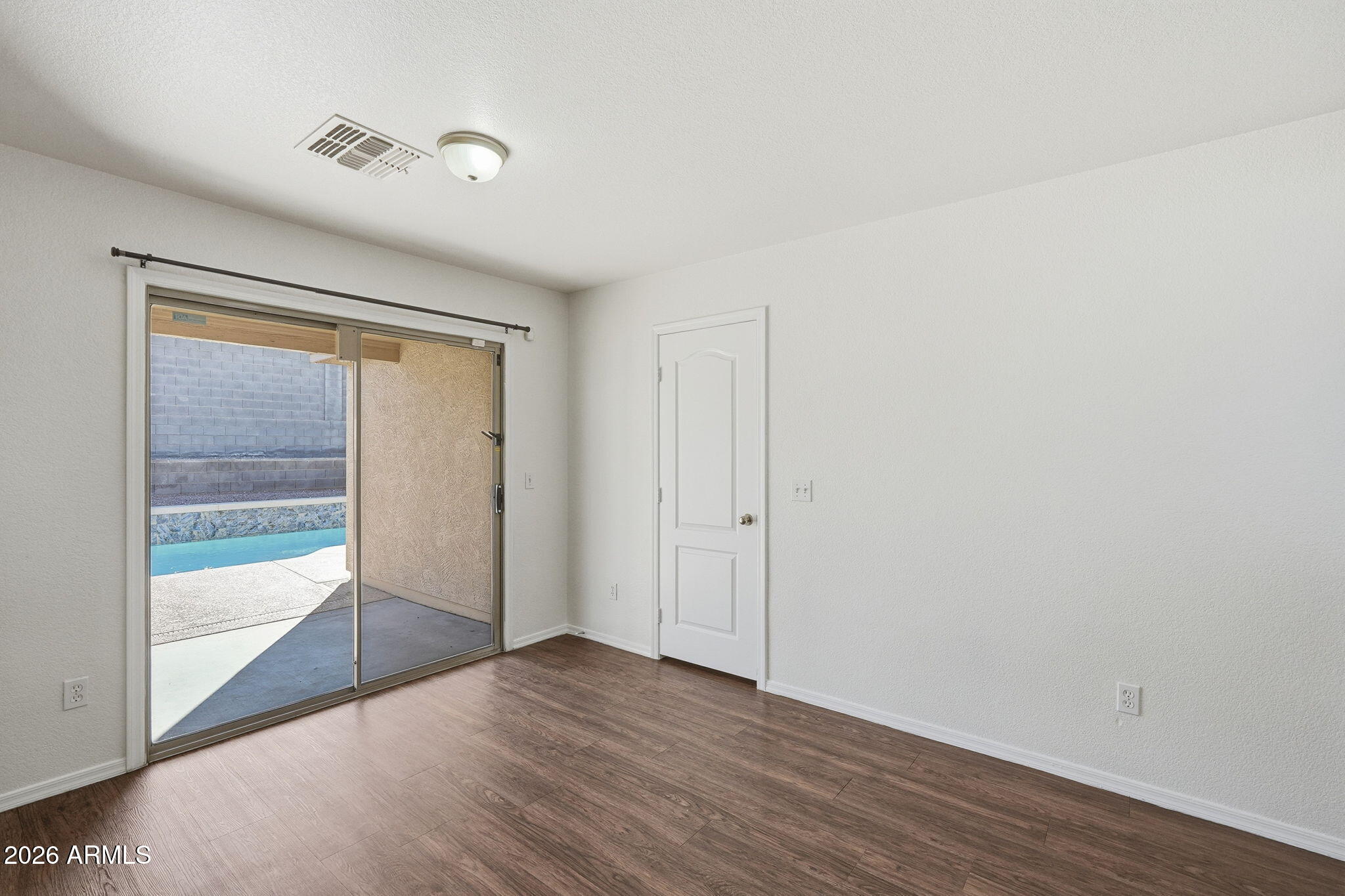 211 East Valley View Drive Phoenix, AZ 85042 - Photo 21 of 47 a view of an empty room with wooden floor and a window