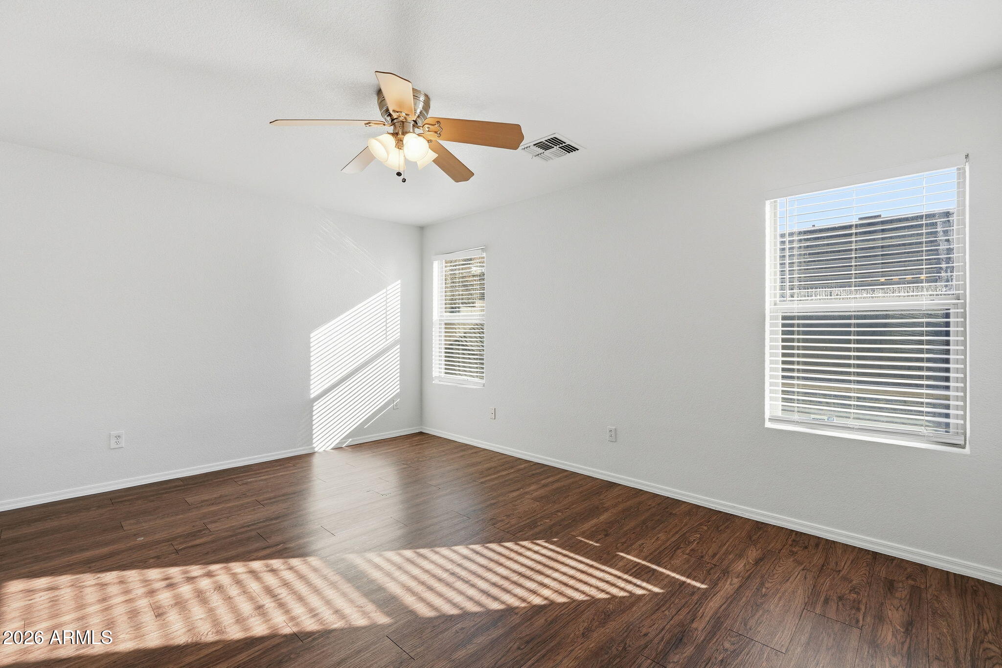 211 East Valley View Drive Phoenix, AZ 85042 - Photo 22 of 47 a view of an empty room with wooden floor and a window