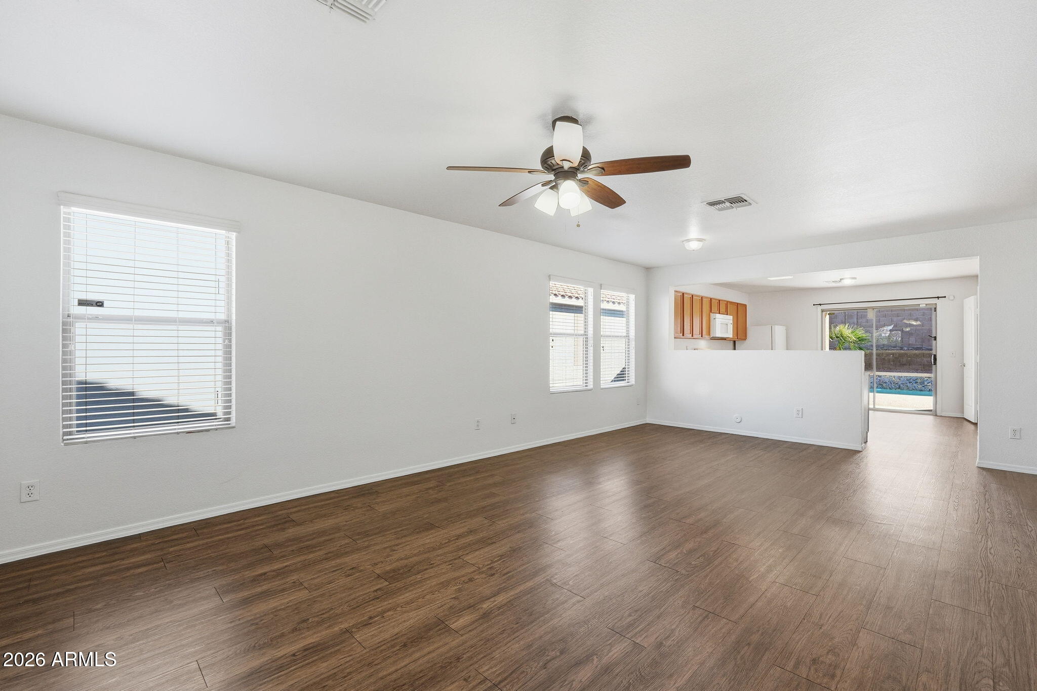 211 East Valley View Drive Phoenix, AZ 85042 - Photo 9 of 47 a view of an empty room with a window and wooden floor