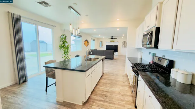 a kitchen with stainless steel appliances granite countertop a sink and refrigerator