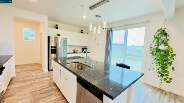 a kitchen with stainless steel appliances kitchen island granite countertop a refrigerator and a stove top oven