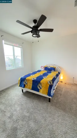 an empty room with ceiling fan and window