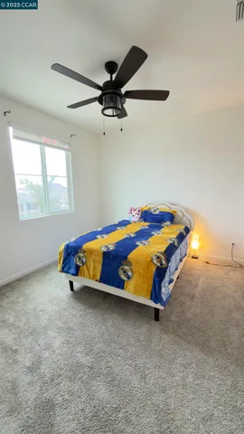 an empty room with ceiling fan and window