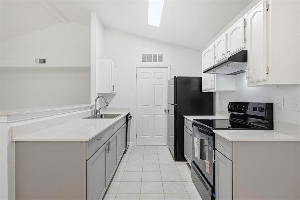 4645 Carr Street The Colony, TX 75056 - Photo 9 of 18 a kitchen with stainless steel appliances a sink stove refrigerator and cabinets