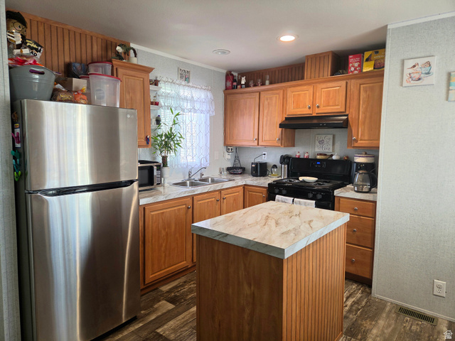 597 North State Street, Unit 67 Orem, UT 84057 - Photo 10 of 23 Kitchen featuring stainless steel appliances, light countertops, a kitchen island, dark wood finished floors, and ornamental molding