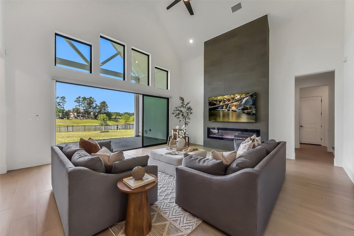 4903 Lagos Lagoon Way Spring, TX 77389 - Photo 18 of 49 Two-story family room features large multi-slide door, automatic shades and lake views that bring the outdoor in.