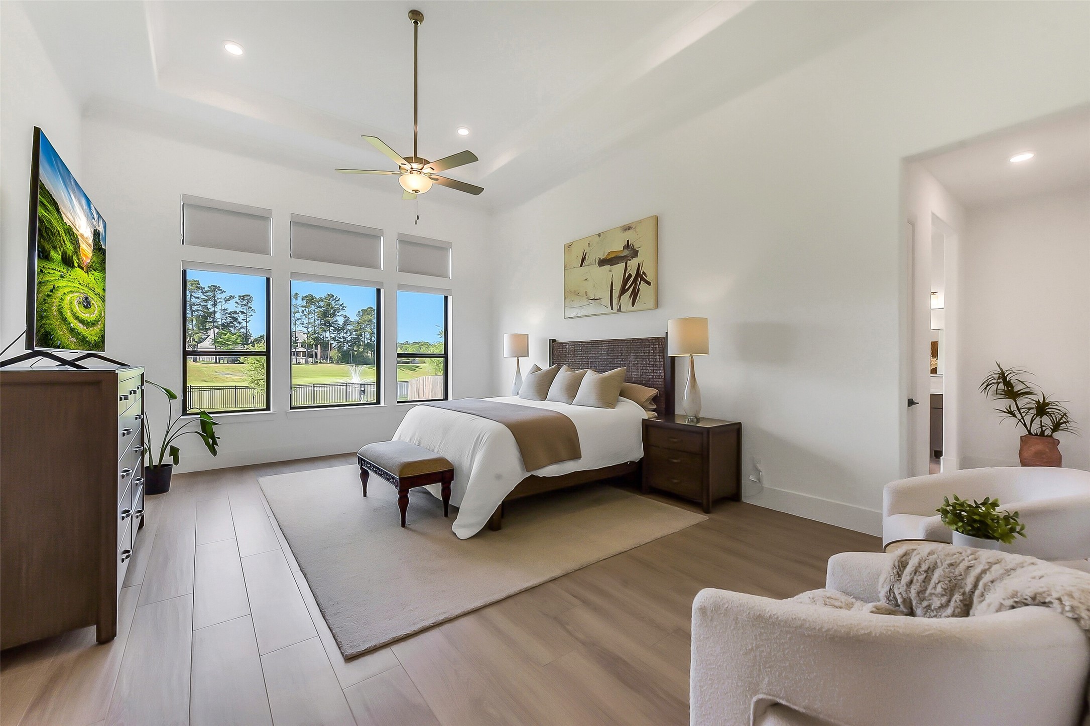 4903 Lagos Lagoon Way Spring, TX 77389 - Photo 23 of 49 Primary suite continued with the wide plank ceramic tile floors, tray ceilings, and wall of windows with the lake view.