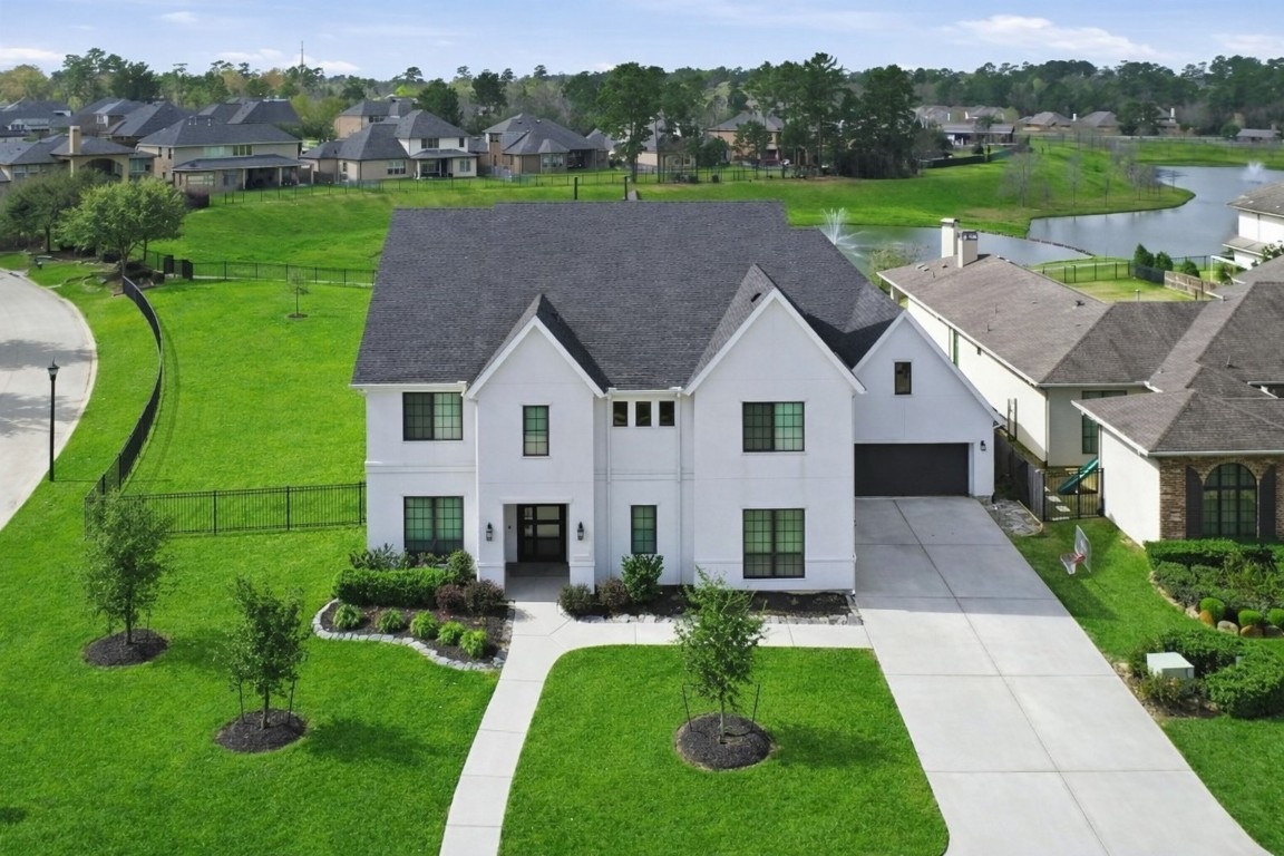 4903 Lagos Lagoon Way Spring, TX 77389 - Photo 6 of 49 Modern two-story home with expansive green space and serene water views. Crisp white exterior, clean architectural lines, and a spacious driveway located in Tres Lagos- gated section of McKenzie Park.