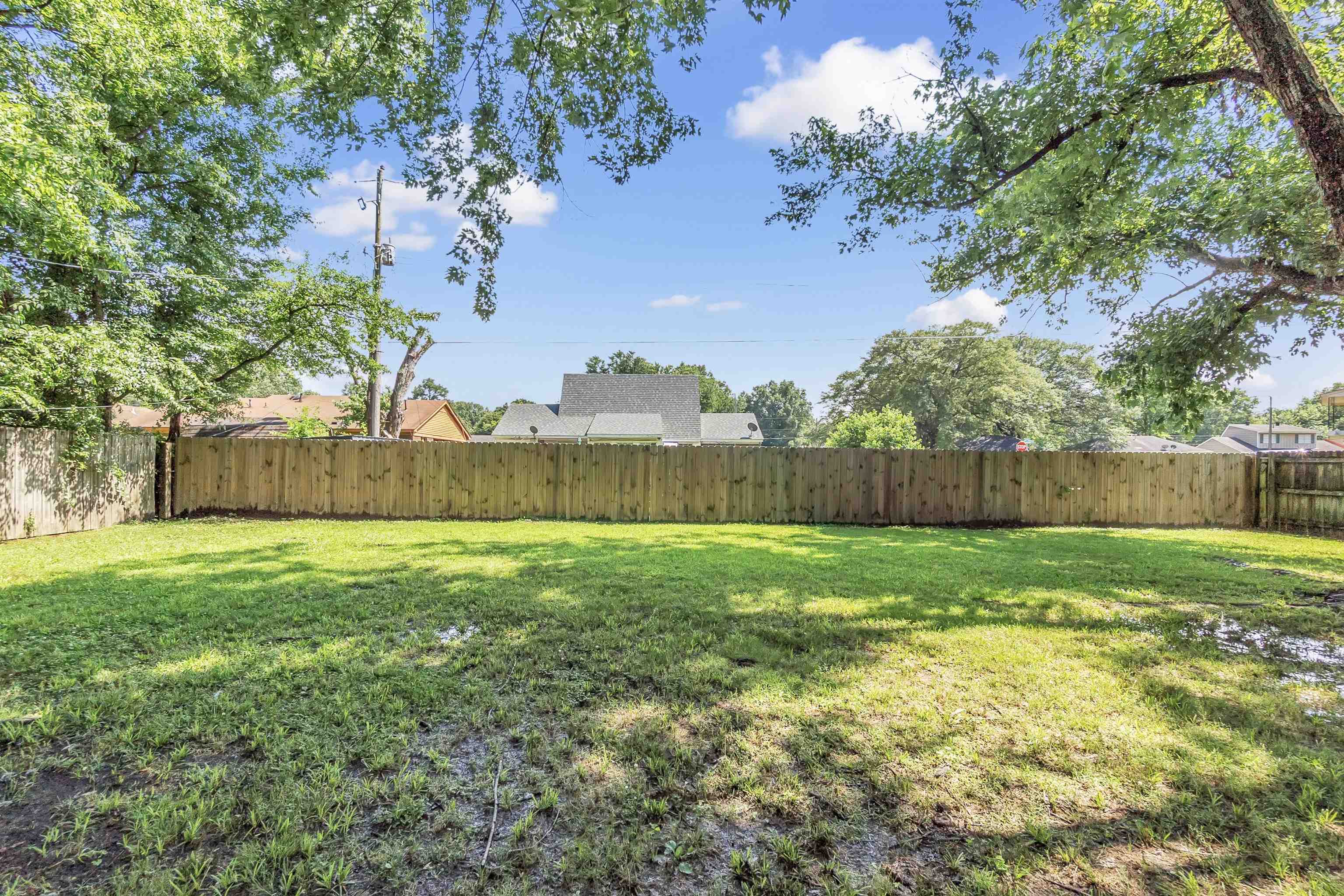 4159 Cochese Road Memphis, TN 38118 - Photo 17 of 18 a view of a backyard with large trees and wooden fence