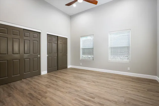 a view of an empty room with window and wooden floor