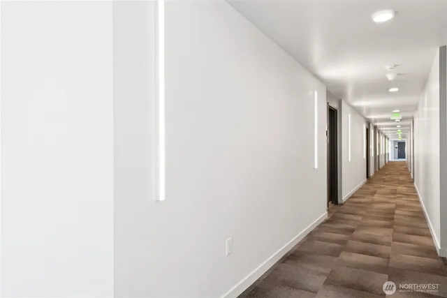 a view of a hallway with wooden floor