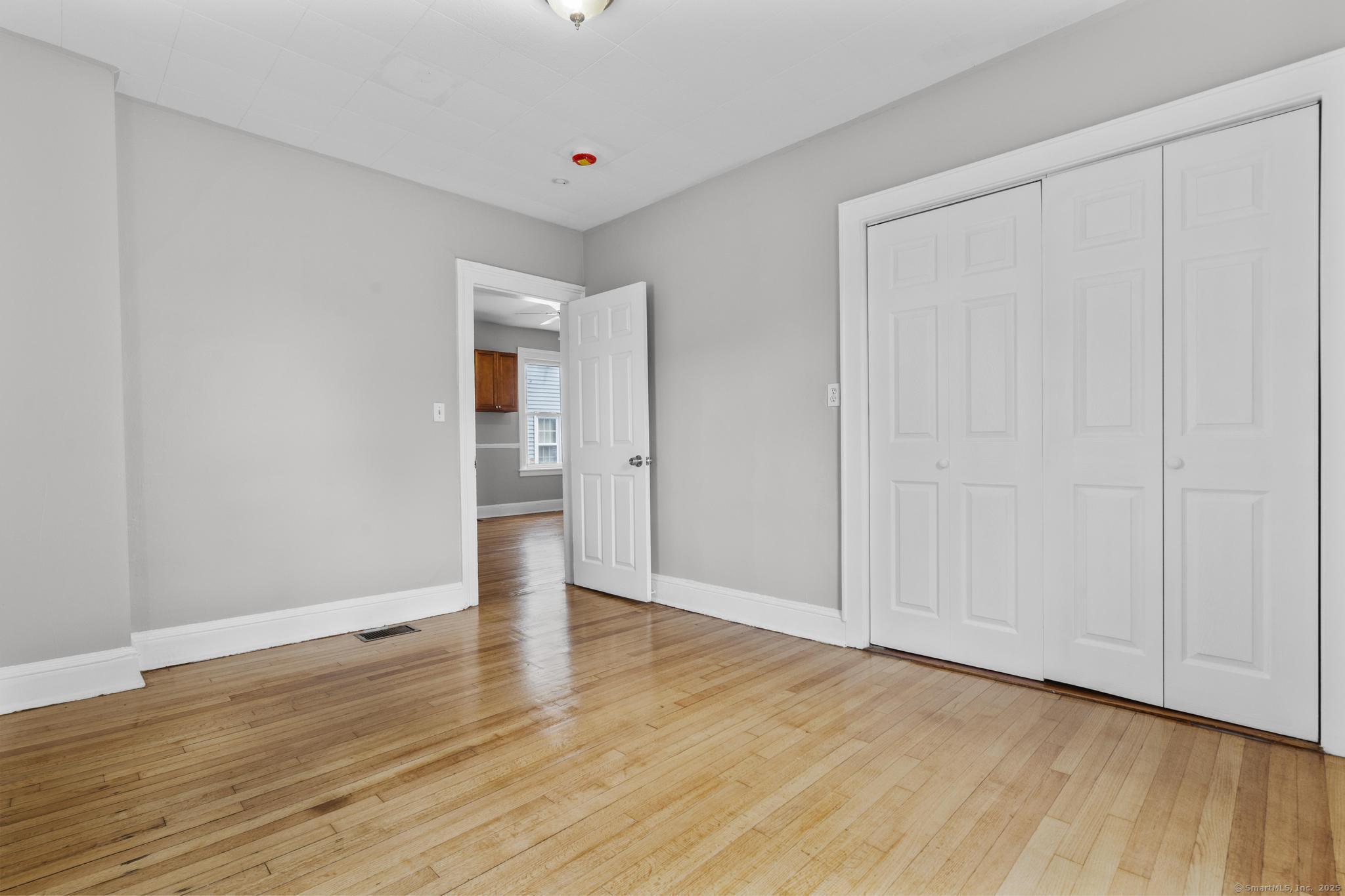 857 Noble Avenue, Unit 1 Bridgeport, CT 06608 - Photo 12 of 16 a view of an empty room with wooden floor
