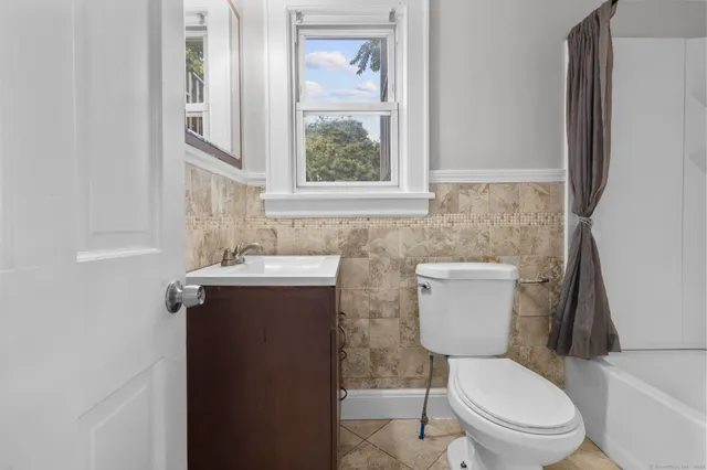 a bathroom with a toilet a sink and a window