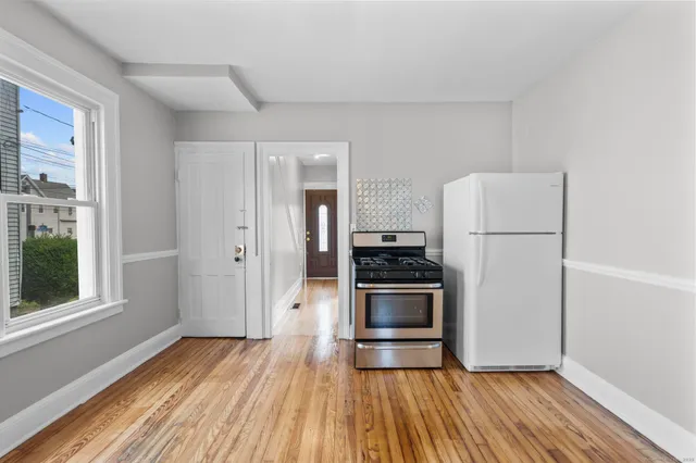 a kitchen with a refrigerator and wooden floor