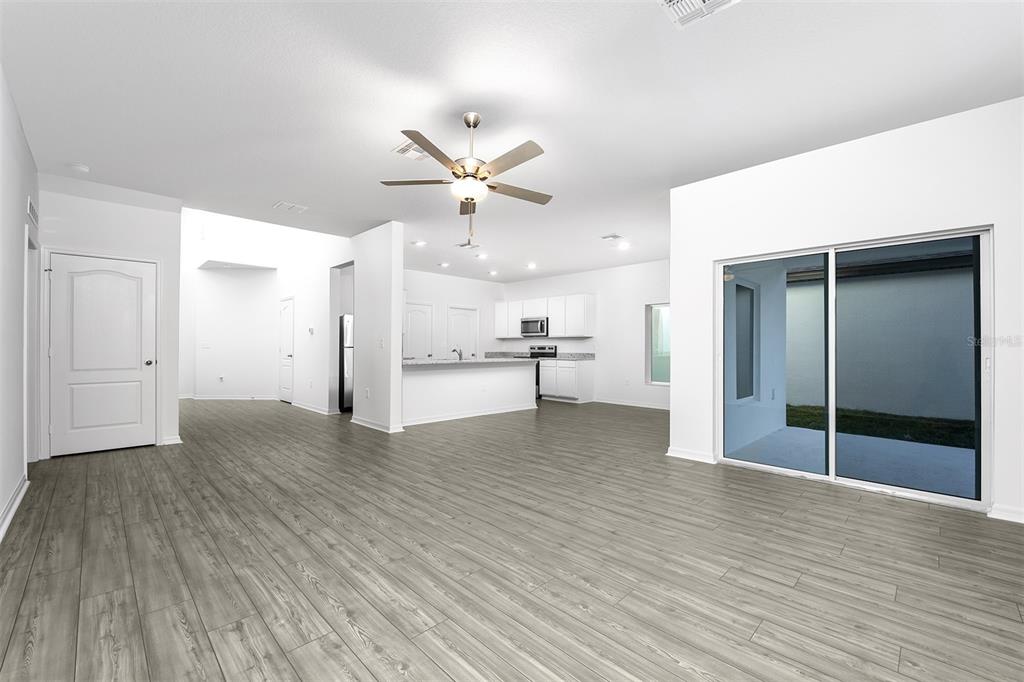 13340 Tula Loop Astatula, FL 34705 - Photo 4 of 21 a view of a kitchen with wooden floor and a ceiling fan