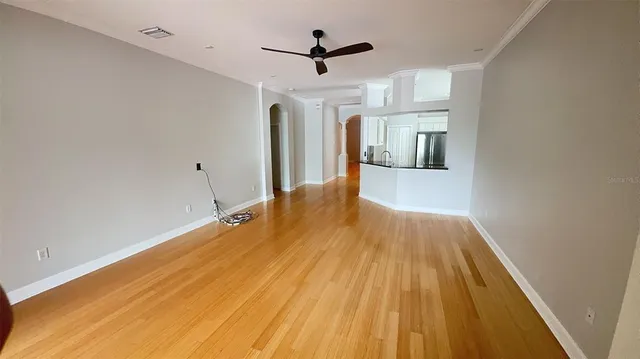 a view of a big room with wooden floor and a ceiling fan