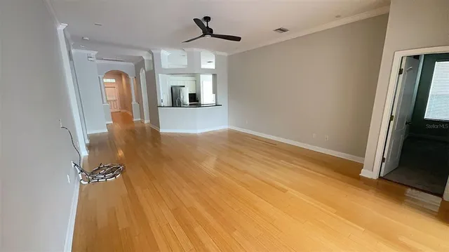a view of a hallway view with wooden floor and a flat screen tv