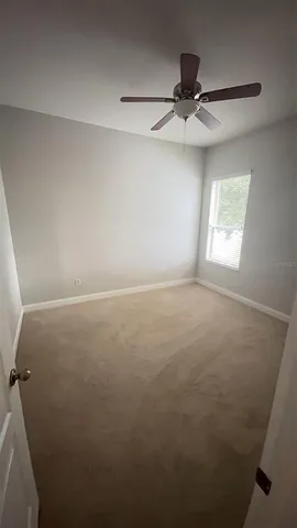 en empty room with windows and fan