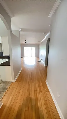 a view of wooden floor in an empty room with a window