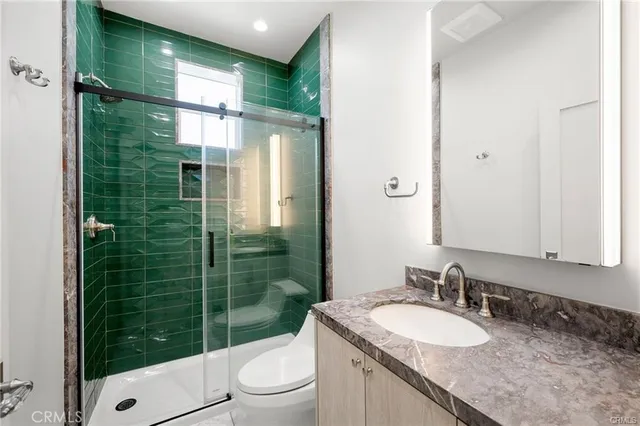 a bathroom with a granite countertop sink toilet and shower
