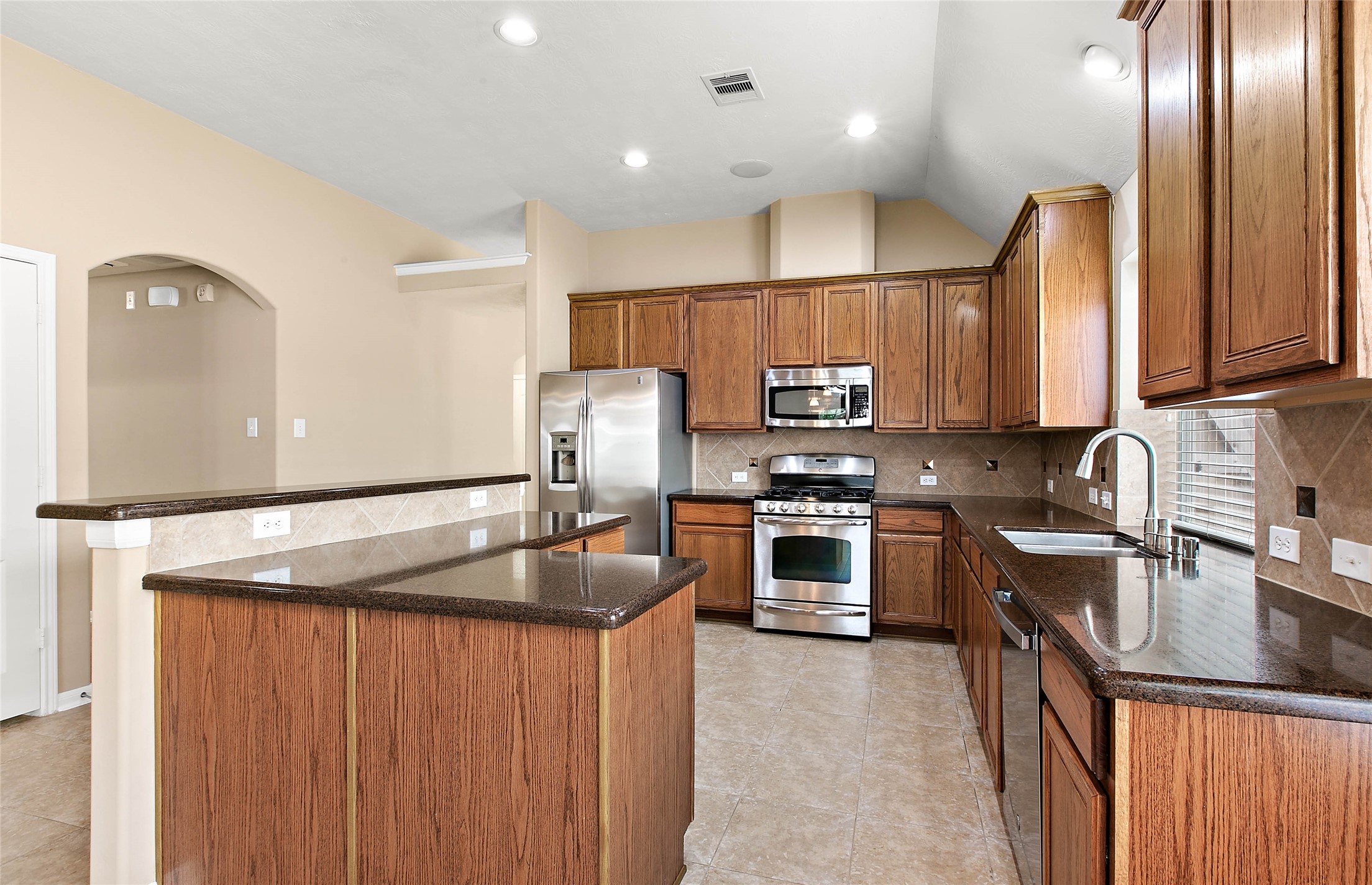 30411 Deleon Fields Drive Spring, TX 77386 - Photo 9 of 24 Kitchen features rich wood cabinetry, stainless steel appliances, and ample counter space.
