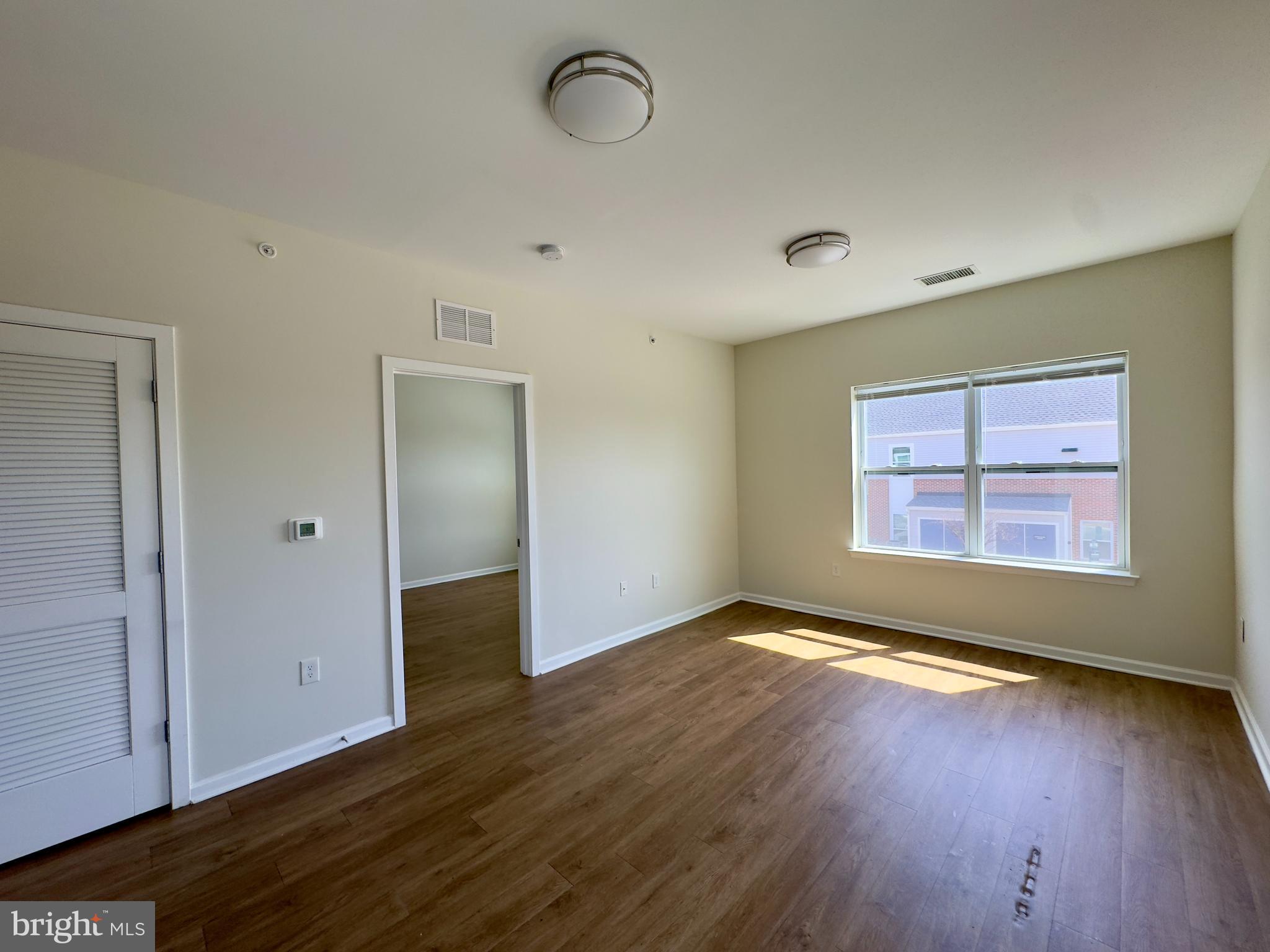 4901 Hamilton Avenue, Unit 4901B Baltimore, MD 21206 - Photo 2 of 10 an empty room with wooden floor and windows