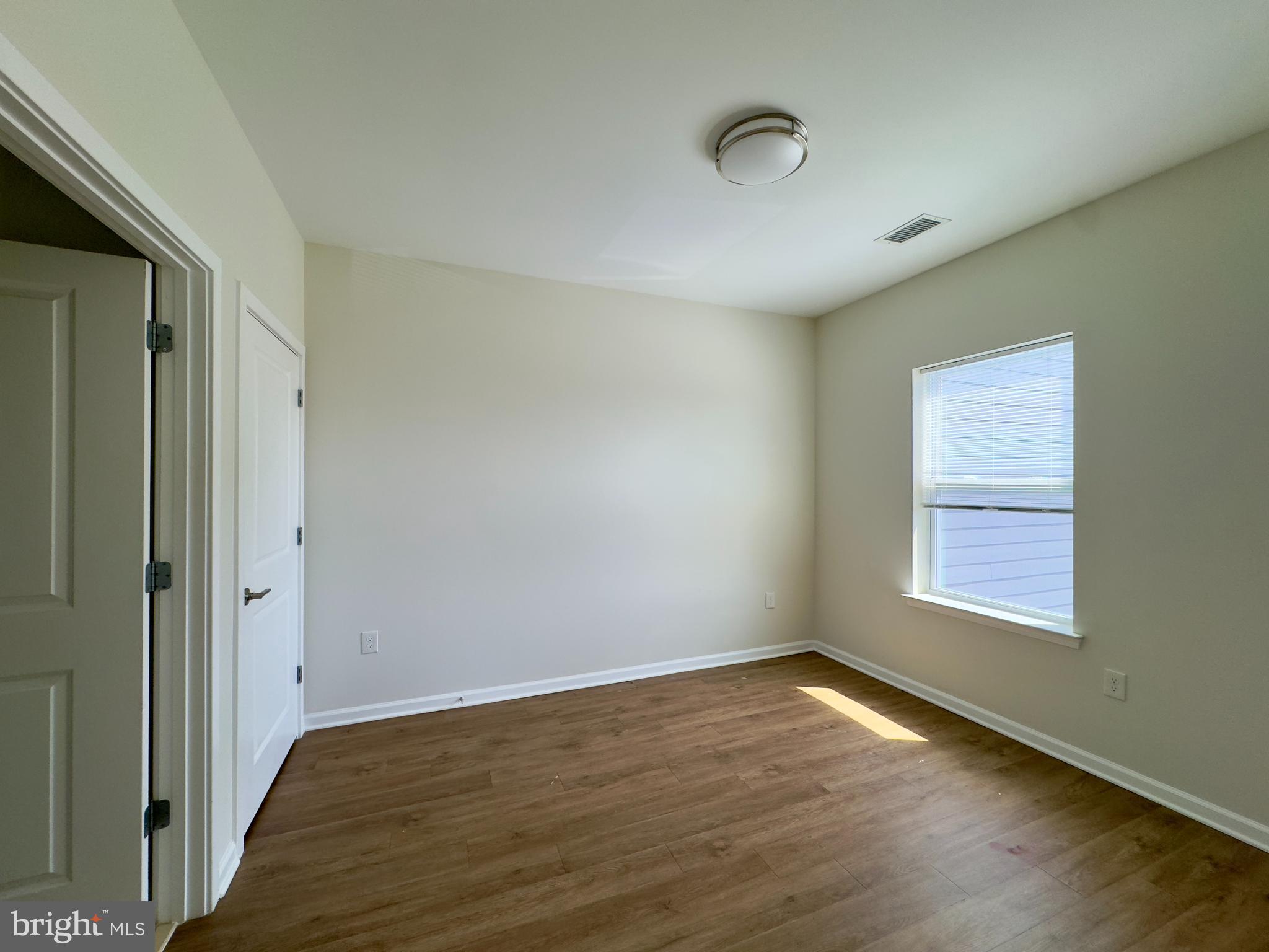 4901 Hamilton Avenue, Unit 4901B Baltimore, MD 21206 - Photo 4 of 10 an empty room with wooden floor and windows