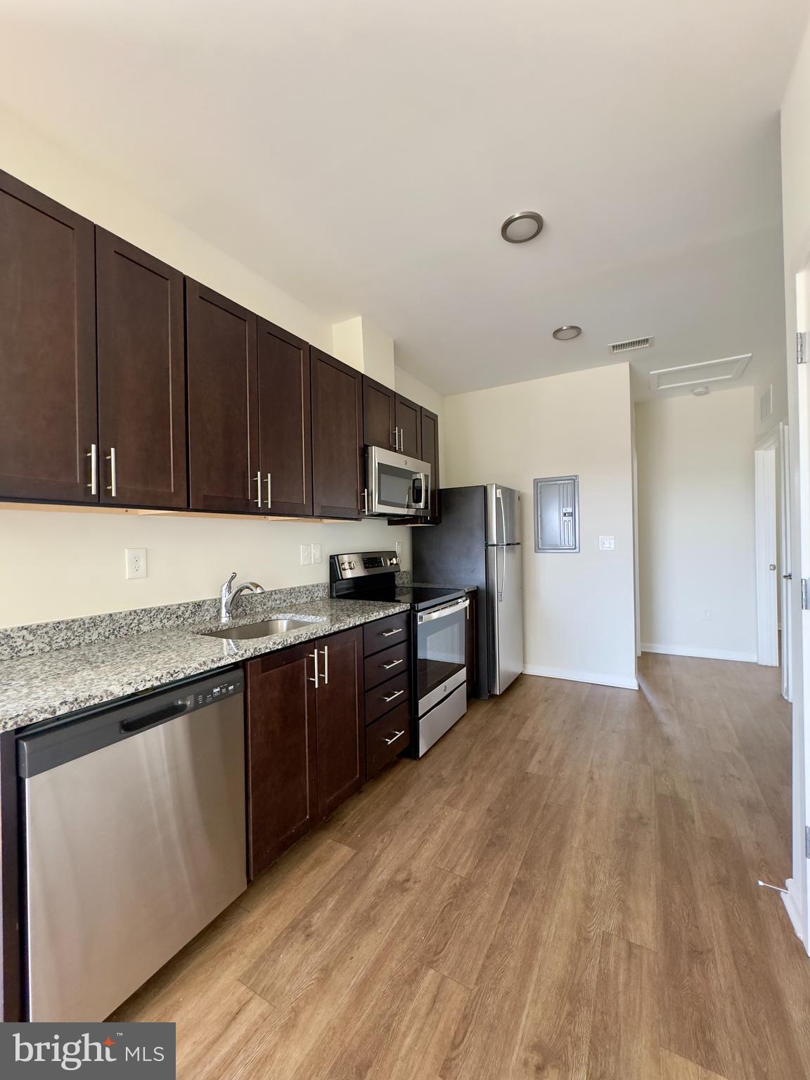 4901 Hamilton Avenue, Unit 4901B Baltimore, MD 21206 - Photo 6 of 10 a kitchen with granite countertop stainless steel appliances and wooden cabinets